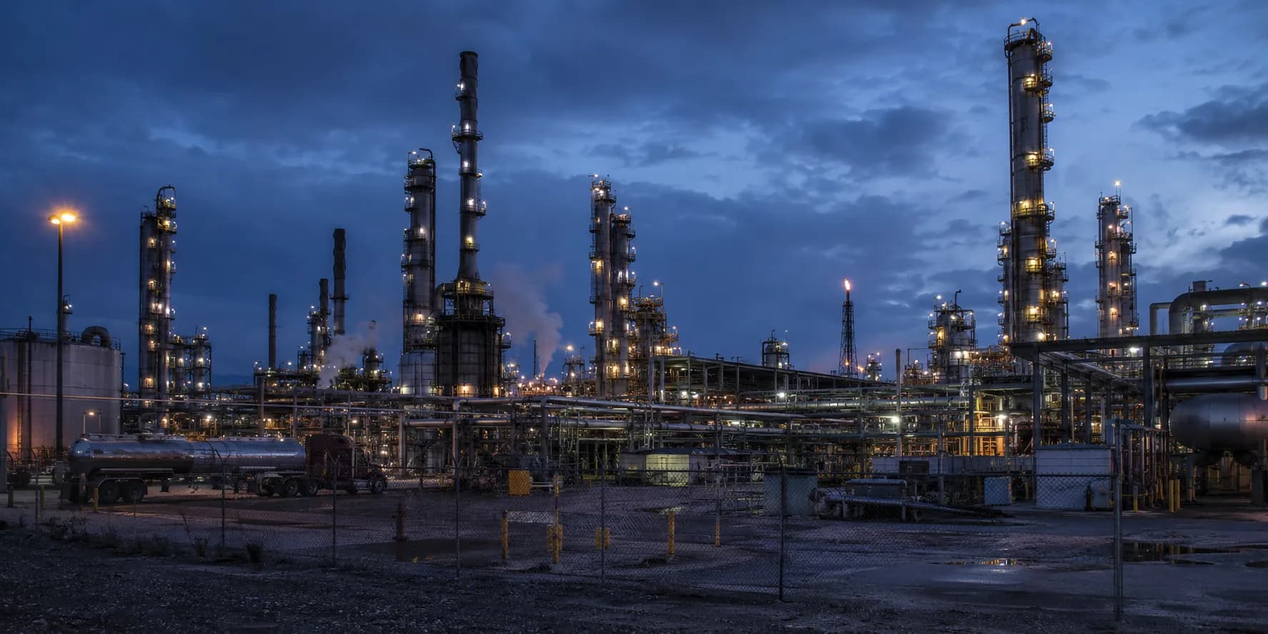 Oil and gas refinery process units and pipework at blue-hour dusk